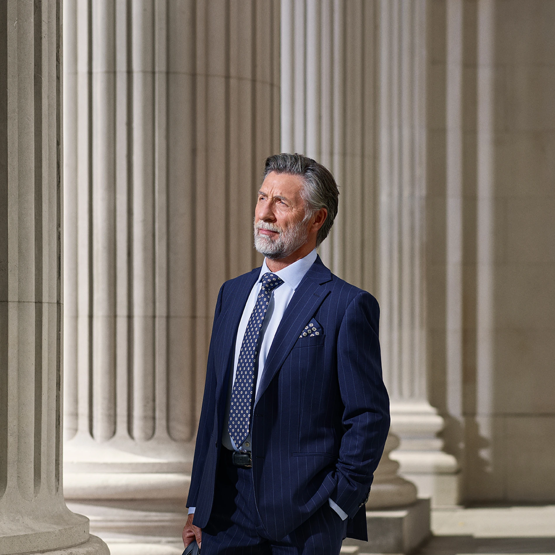 Executive in Suit Standing in Front of Columns