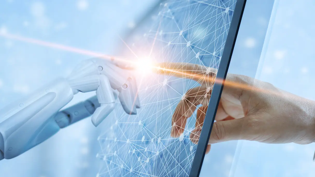 A robotic hand and a human hand touching fingertips across a glowing digital screen displaying a geometric network grid