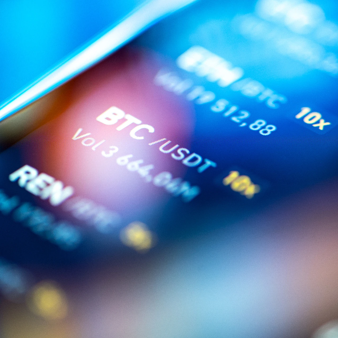 Close-up of a digital cryptocurrency trading screen displaying BTC/USDT pair, volume 3,664.94M, with blue and yellow text on a dark blurred background.