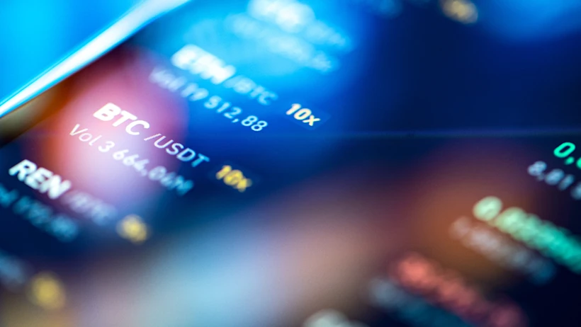 Close-up of a digital cryptocurrency trading screen displaying BTC/USDT pair, volume 3,664.94M, with blue and yellow text on a dark blurred background.