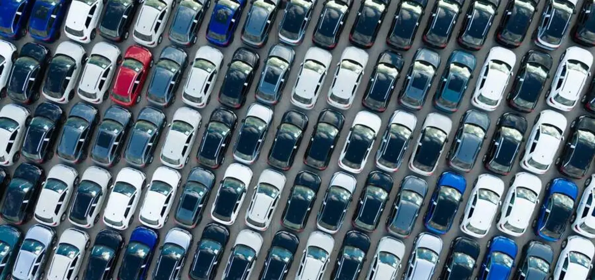 Aerial view of rows of parked new cars in various colors.