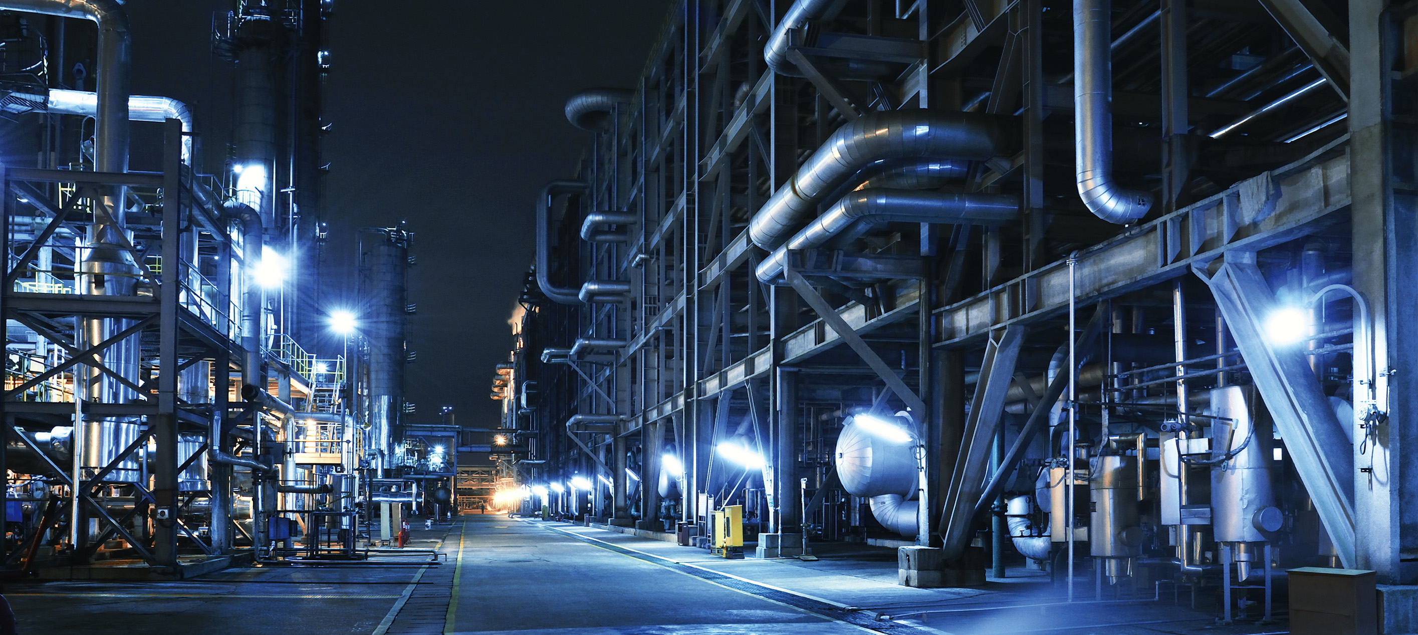 sprawling industrial petrochemical complex or oil refinery at night