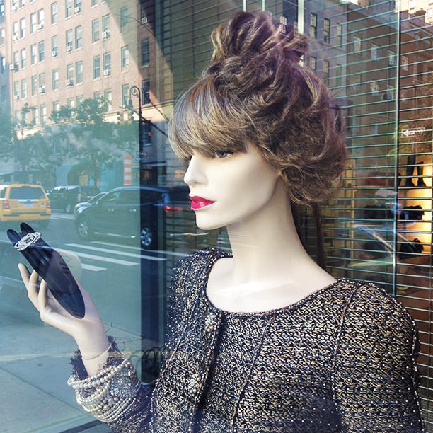 Female stylish mannequins in a shop window with Chanel bags