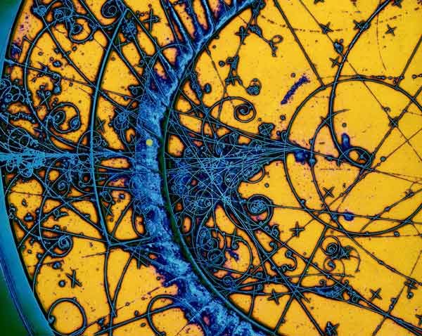 Artistic-enhancement of charged particles passing through a chamber filled with hydrogen-neon liquid leaving bubbles along their paths (Credit: BEBC)