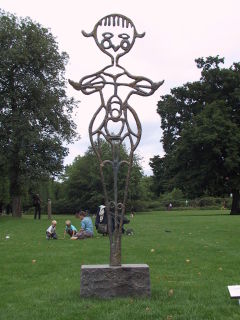 A bronze figure of female form standing on a granite foot