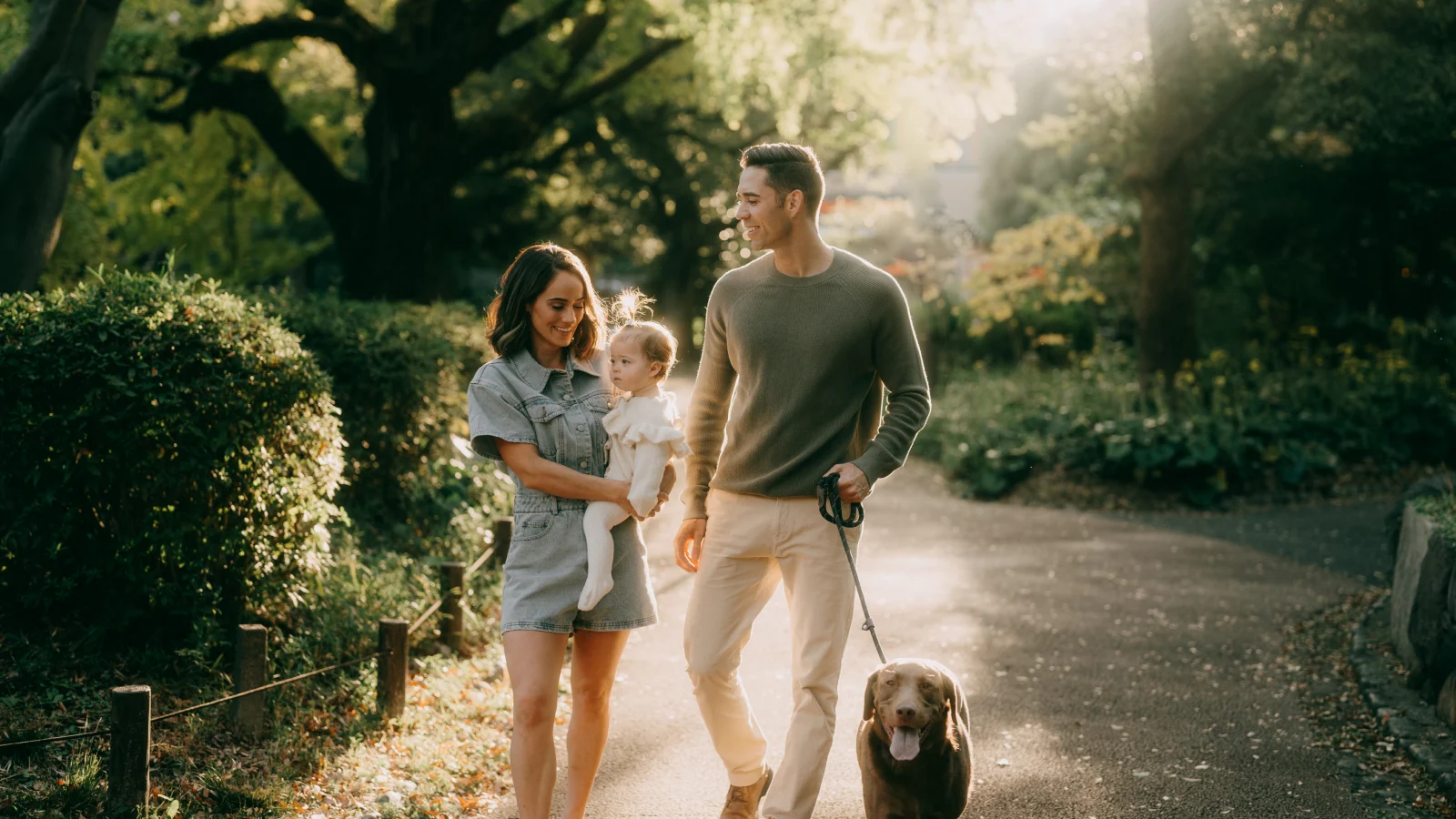 Happy family walking with their dog-in a park
