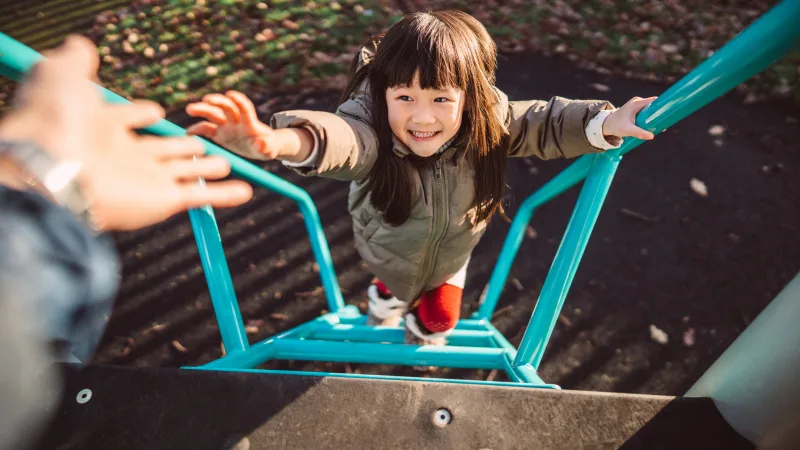 Transform lives - Little girl happily playing in the playground