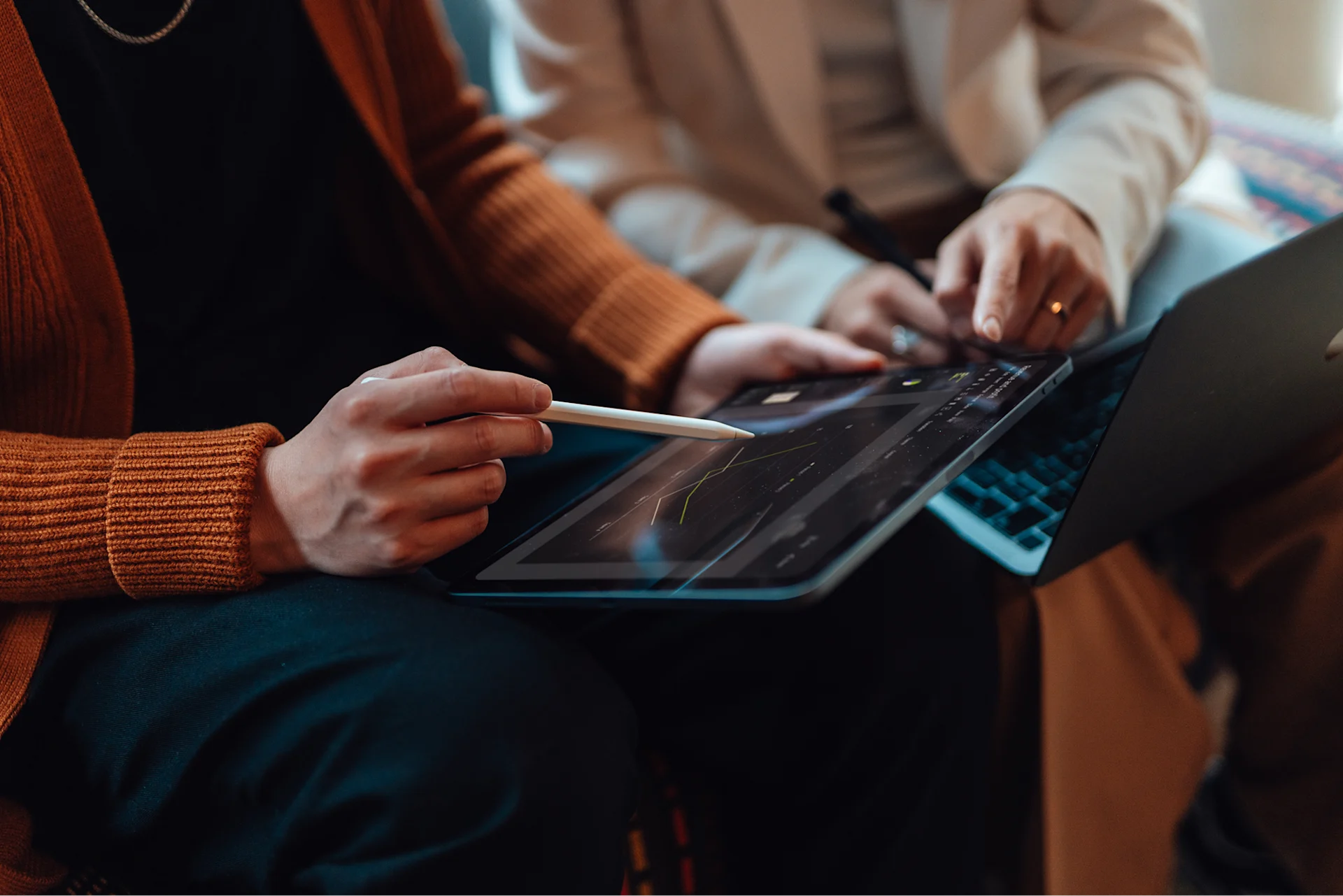 A person holds a stylus over a tablet screen.