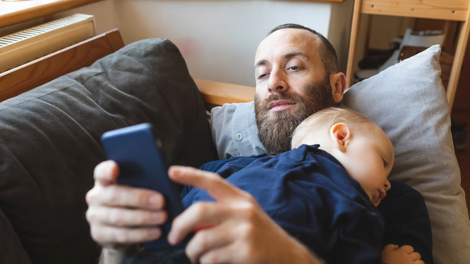 Overview of services - Baby sleeping on top of his father who is looking at his phone