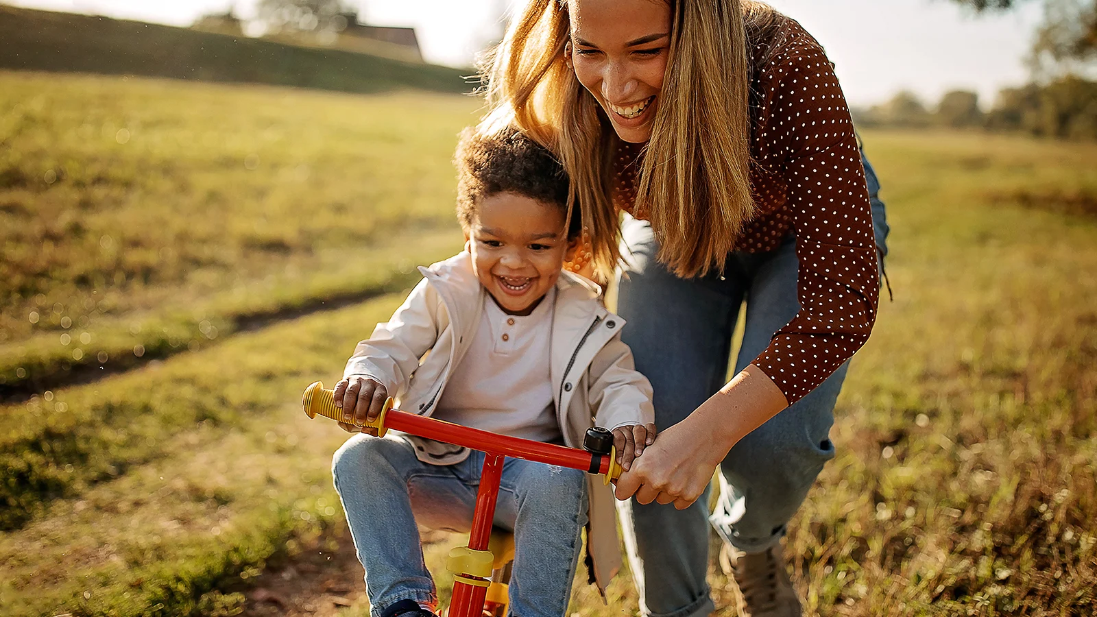 A mother teaching her son how to ride a bike