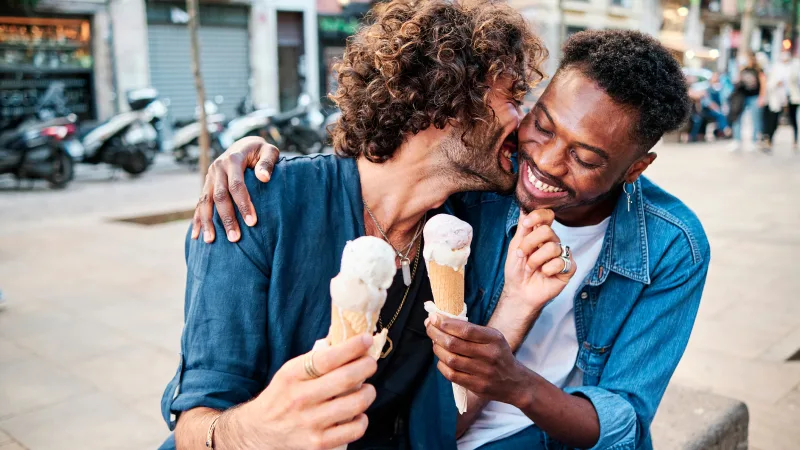 6 financial strategies to help plan for parenthood - Male partners smiling and enjoying ice cream