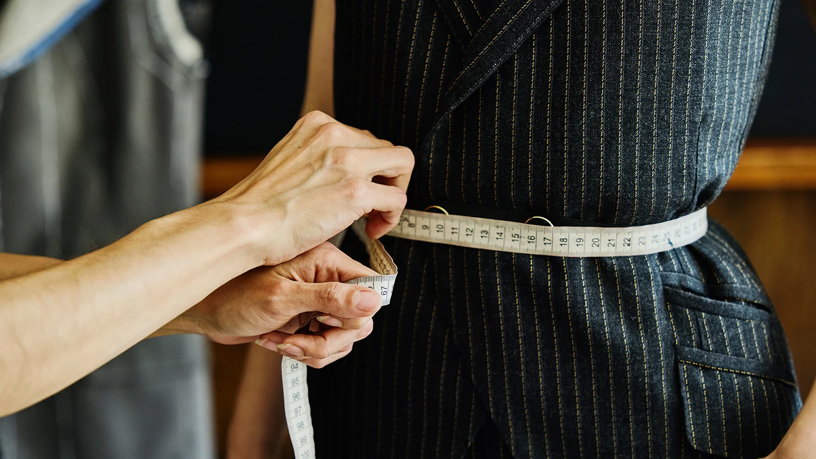 Tailor measuring waist with a measuring tape