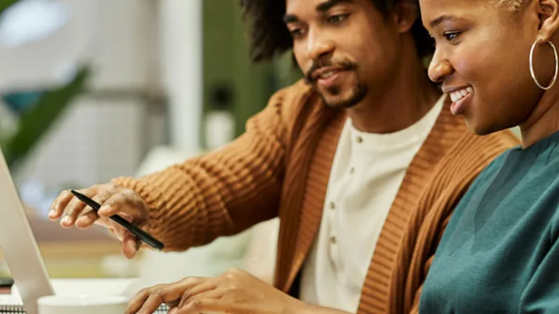 Getting the most for your well-being from work - Two people working together on their laptop