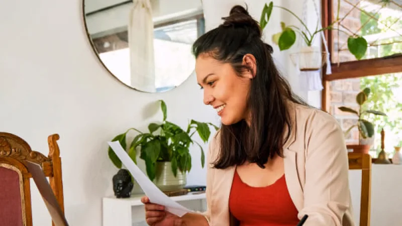 Watch the replay: “Strengthening financial literacy and habits” webinar - Woman reviewing paperwork at desk