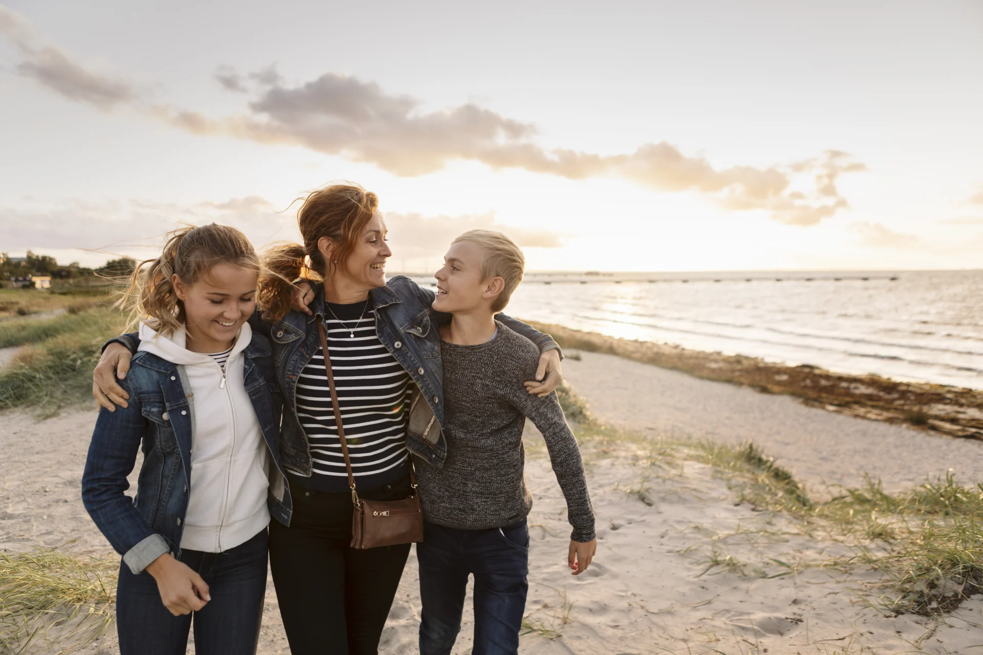 Mind, Body, and Wallet® 2024: Addressing well-being during life’s pivotal moments - A mother and her daughters walking on the beach. 