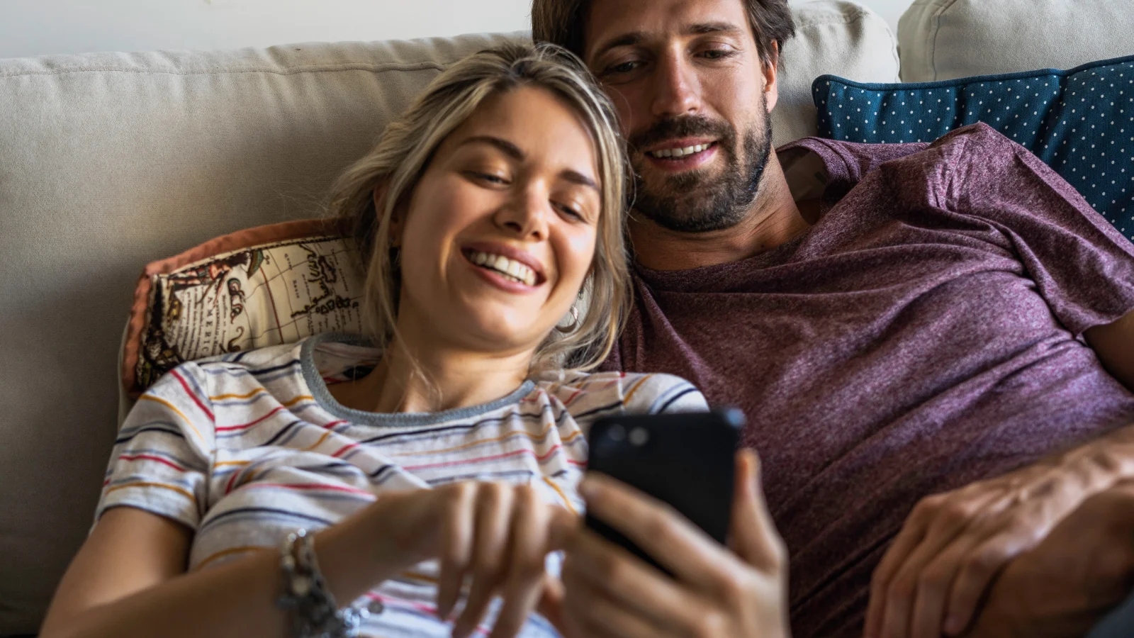 7 easy ways to help improve your finances this week - Couple looking at smartphone