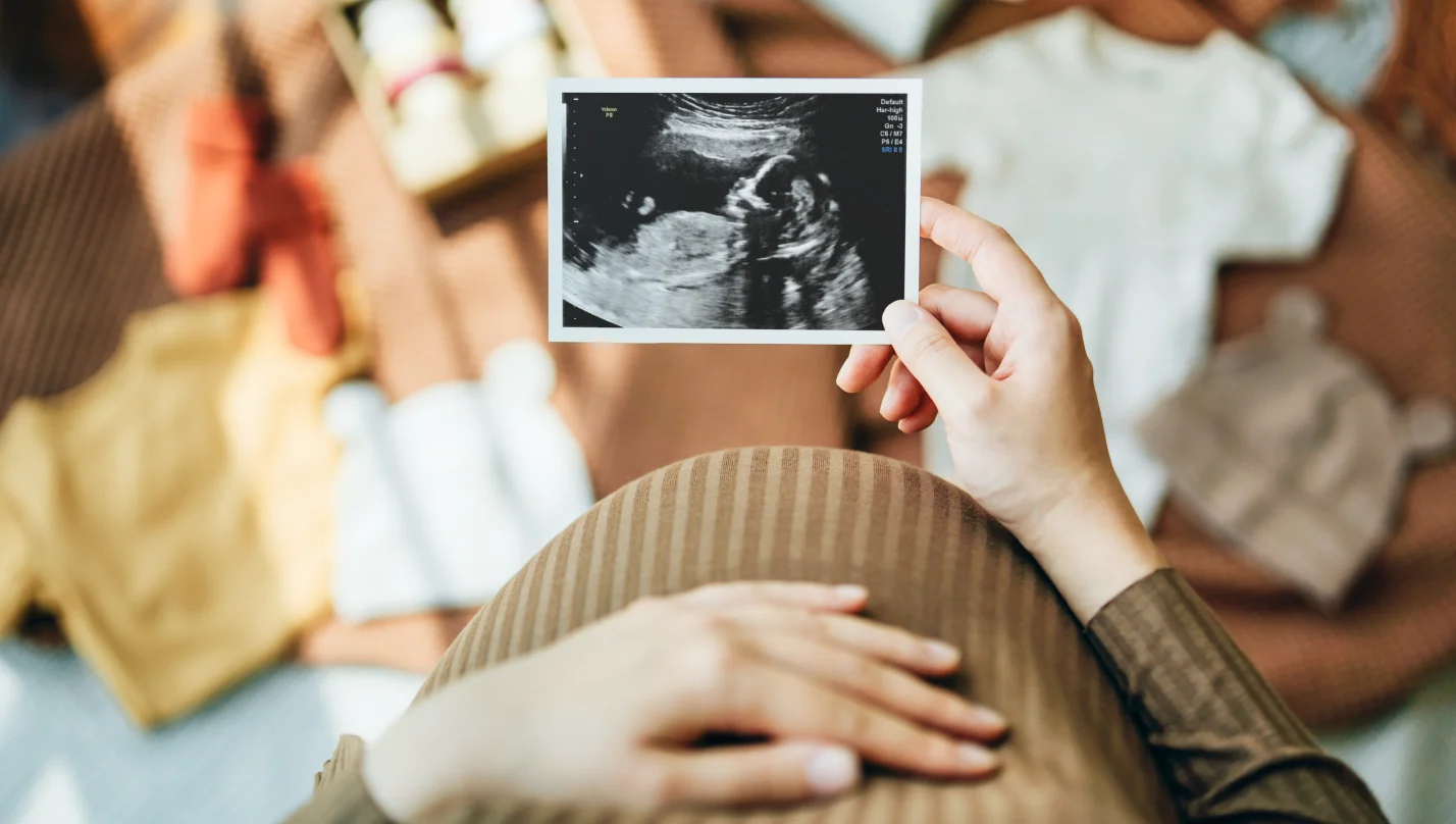 Prepping for parenthood - Pregnant mother looking at an ultrasound image of her baby