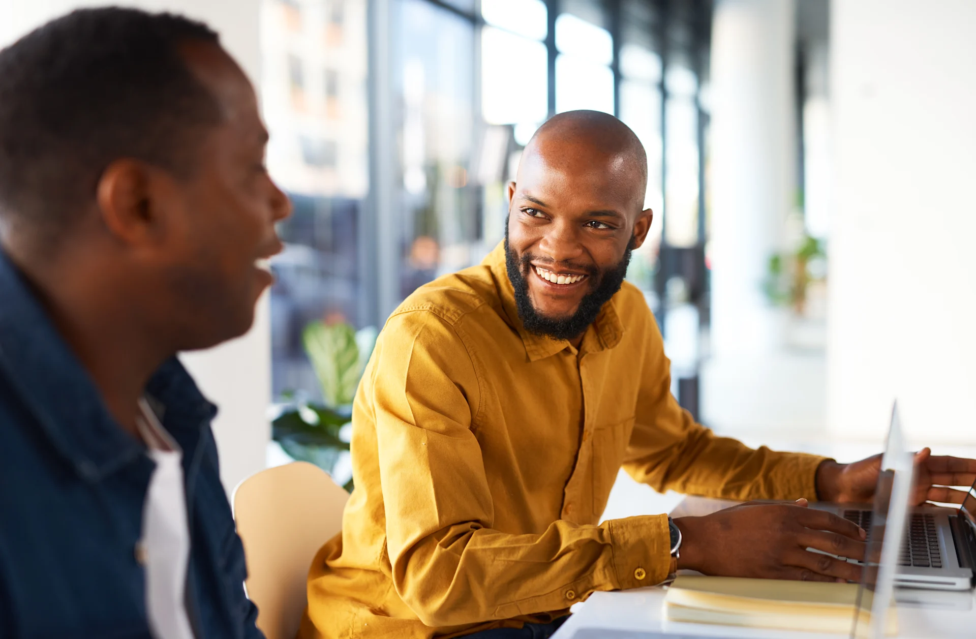 Two coworkers smiling and talking to each other.