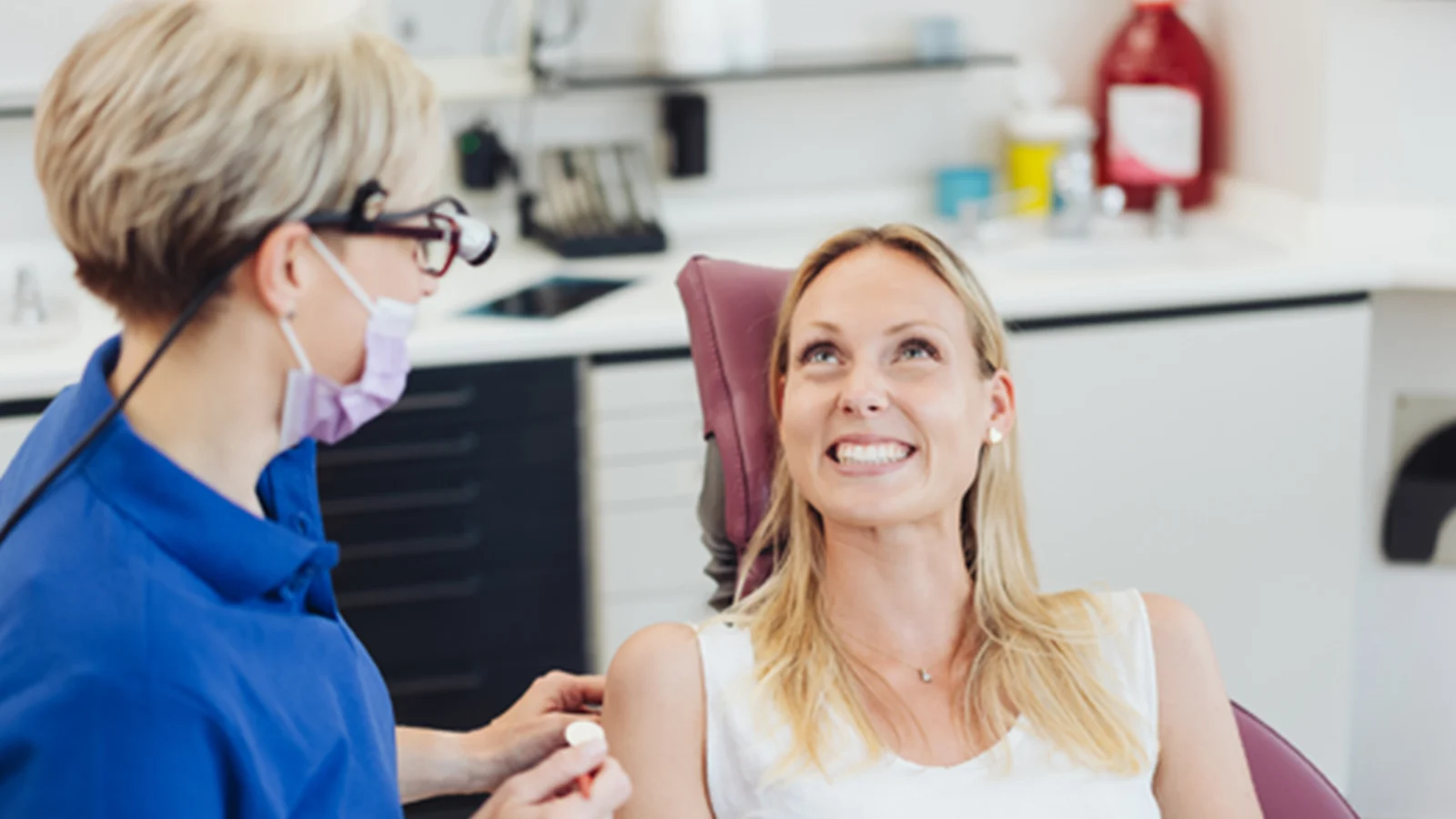 Dentist with an adult female patient during a check up.