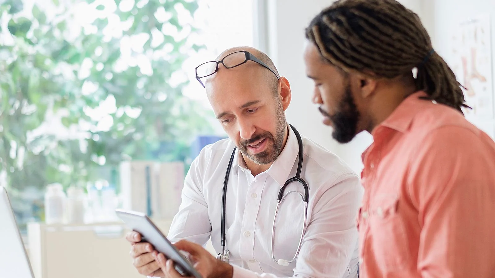 Physician and woman look at tablet