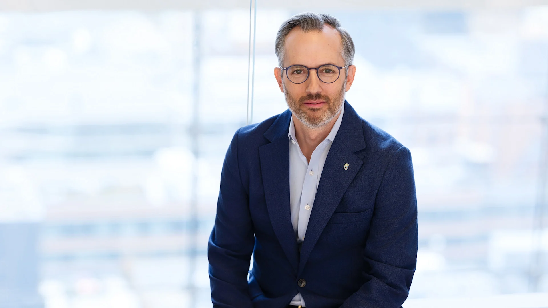 A professional headshot of a CFO wearing eyeglasses and a suit.