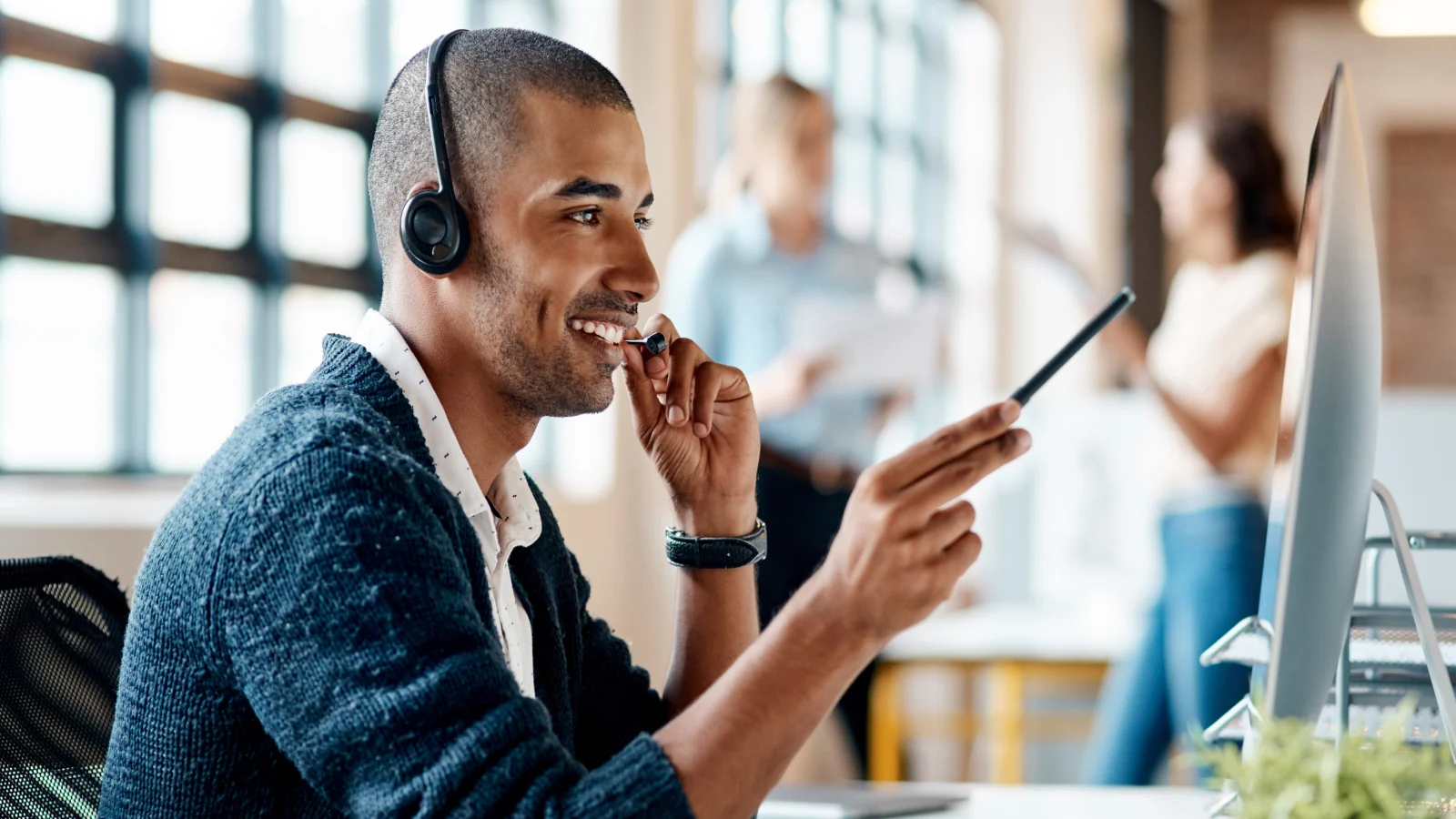 Man wearing a headset while working on his computer