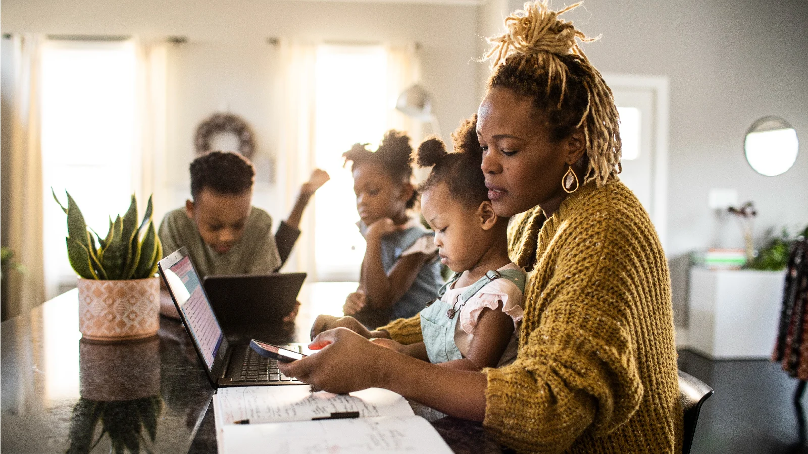 Woman holding a baby on her laptop