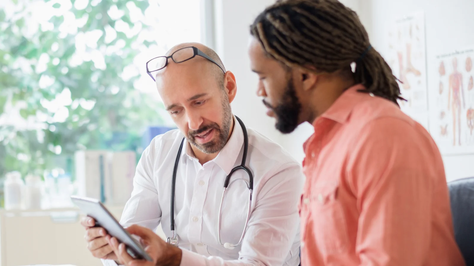 Doctor giving consultation to patient using digital tablet
