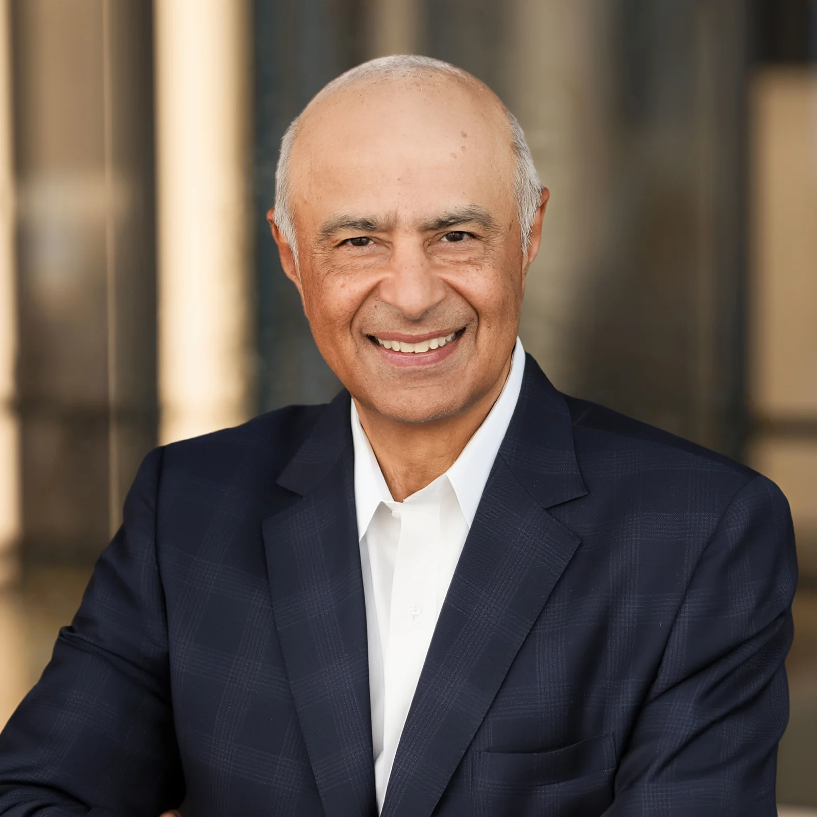 Portrait of Vikram Malhotra in a dark blue suit jacket and white shirt.