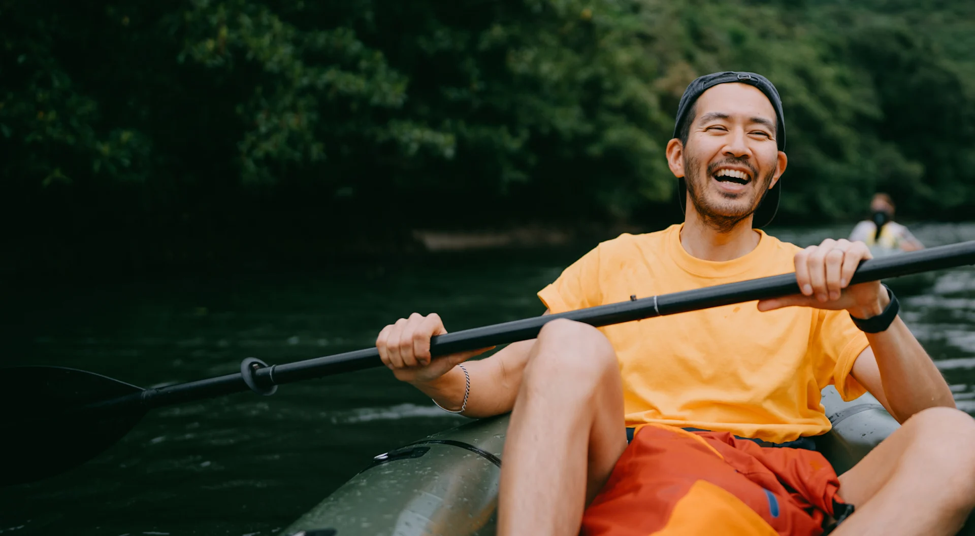 Happy man kayaking down a river