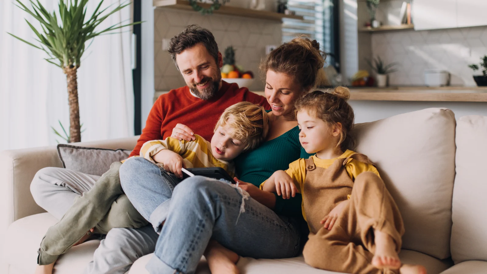 Test your life insurance knowledge - Parents with two young children sitting on a couch at home