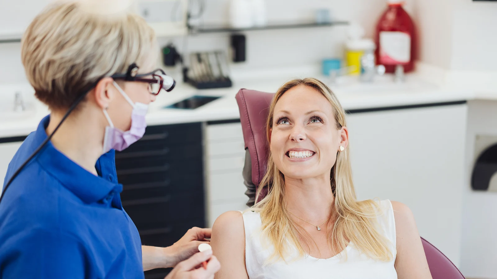 Dentist speaking to patient in chair