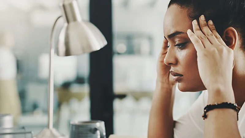 2022 Workforce State of Mind Report - Young woman massaging her temples