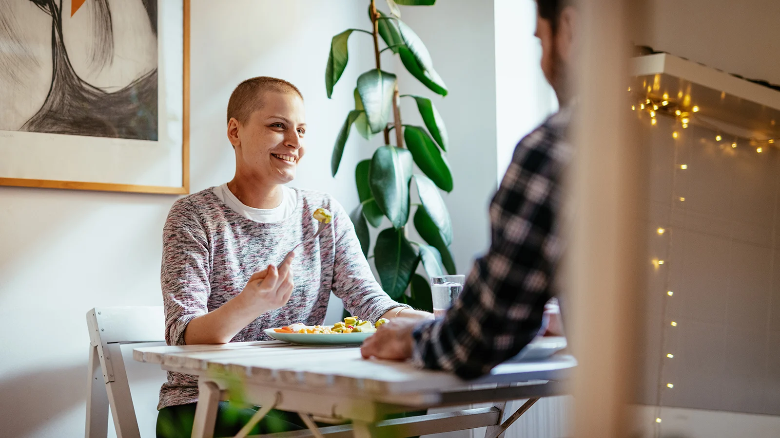 Two people having a meal and conversation together at a dining table.