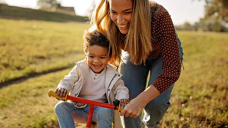 Test your supplemental health benefits knowledge - Mother teaching her son how to ride a bike