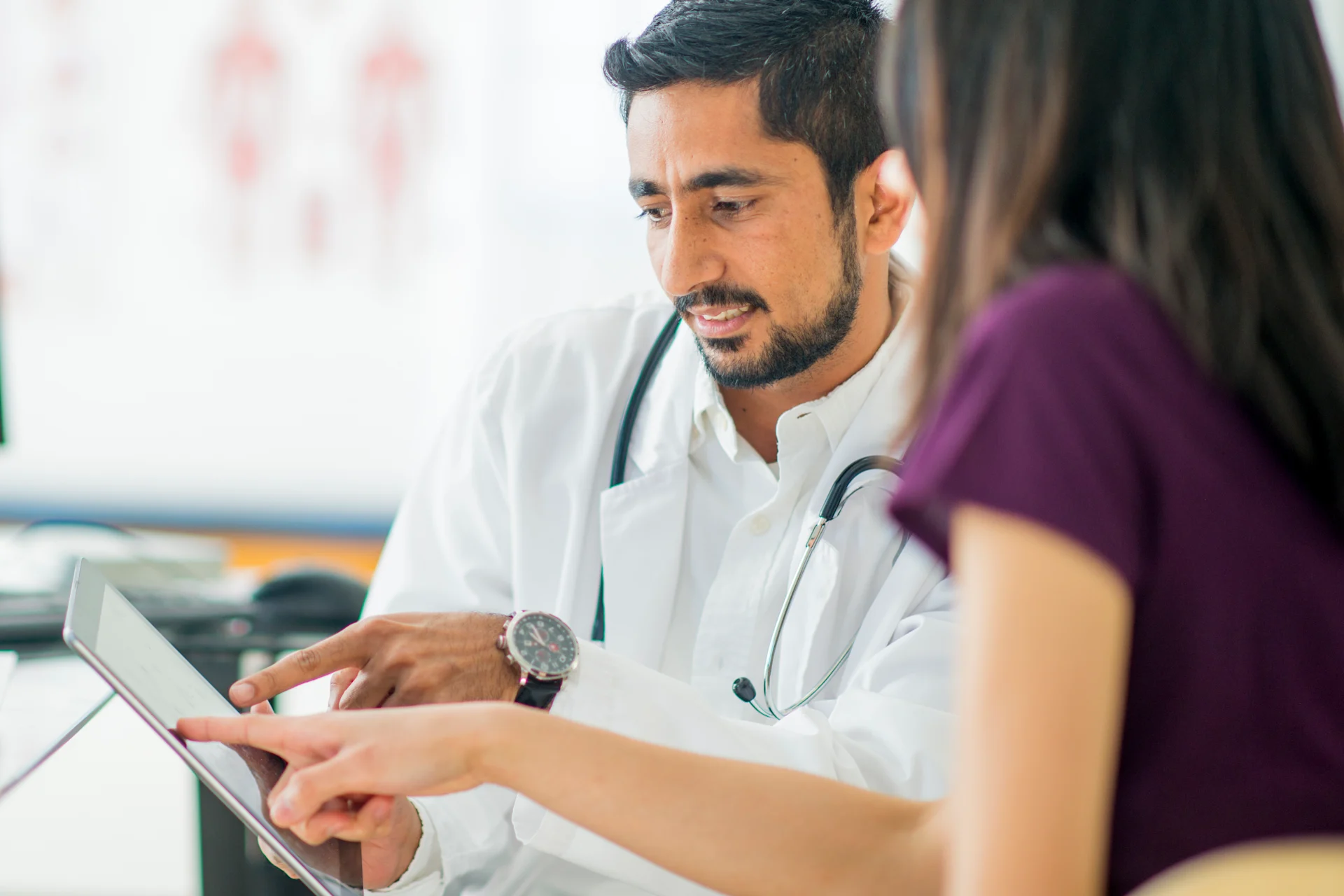 Physician and woman look at tablet