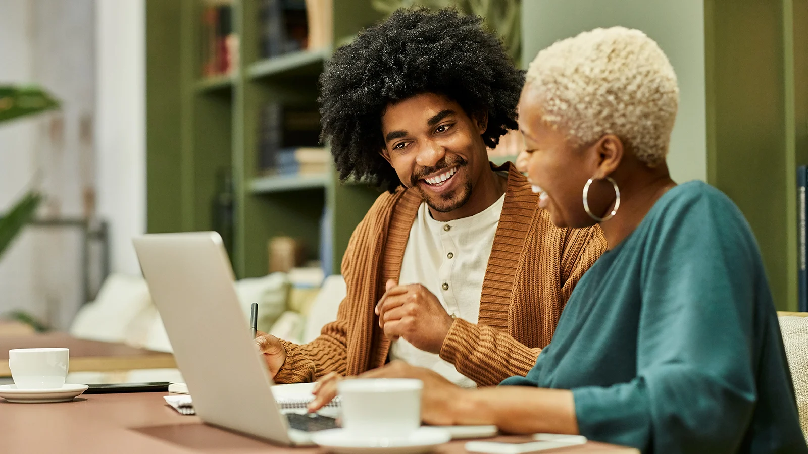 Two co-workers looking at a laptop at work