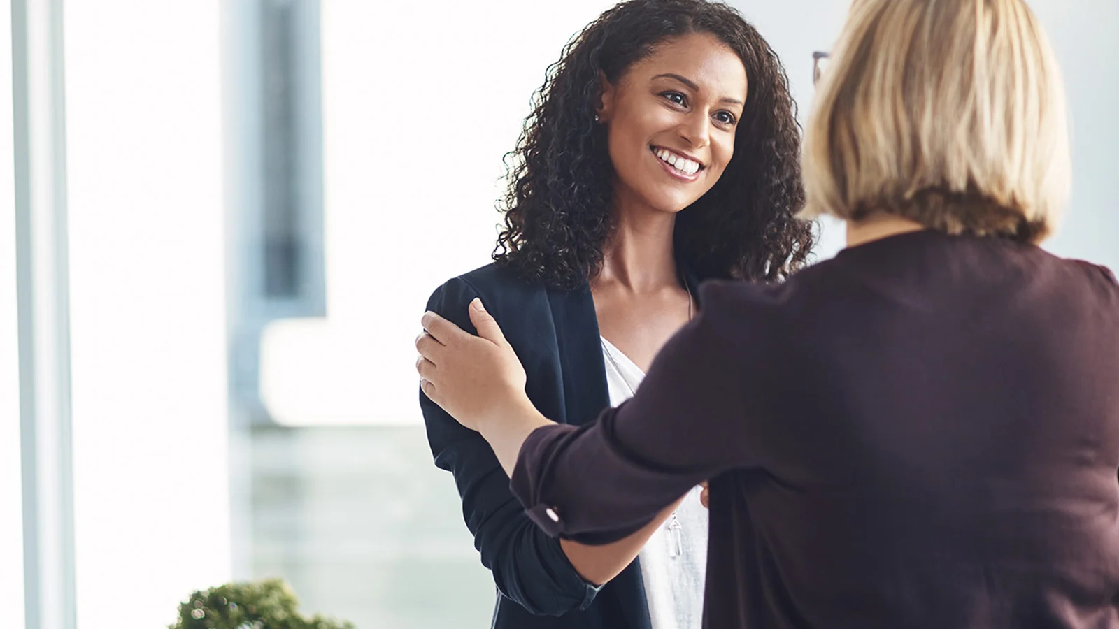 2 women shaking hands in the office