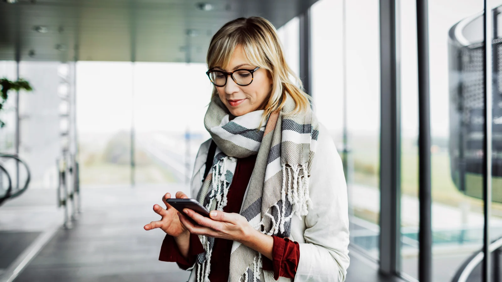 businesswoman-with-phone-standing-at-the-airport