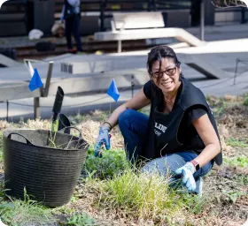 16,000+ - A woman squats in greenery to weed the High Line