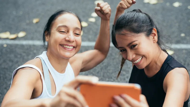 Focused on what matters to you - Two girls take a selfie while flexing their arms
