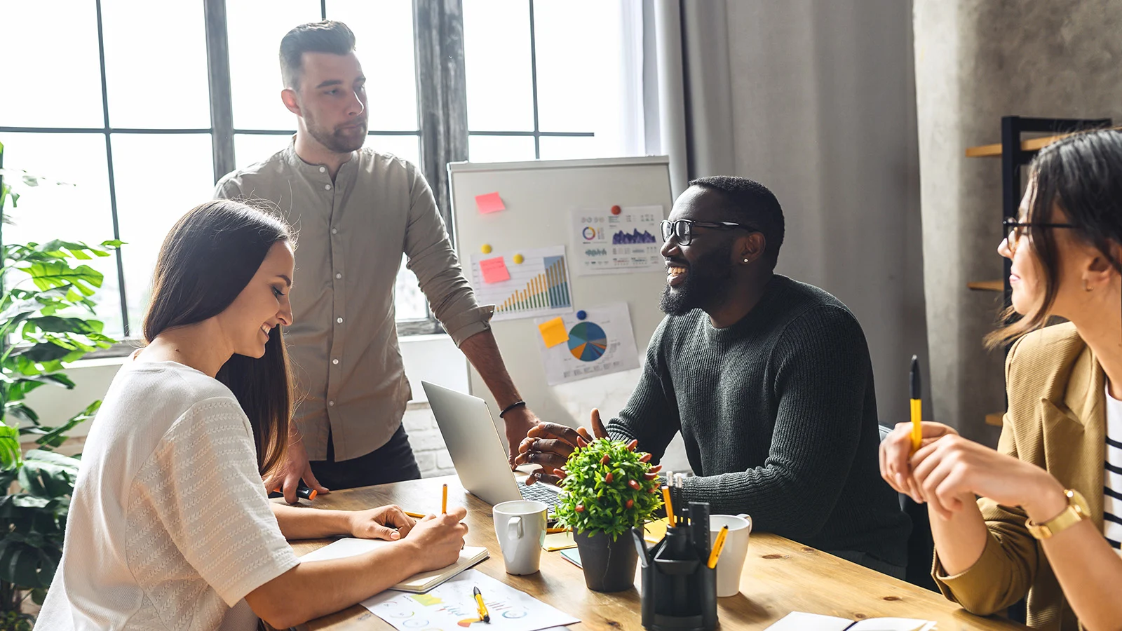 Four coworkers meeting around a table in an office.