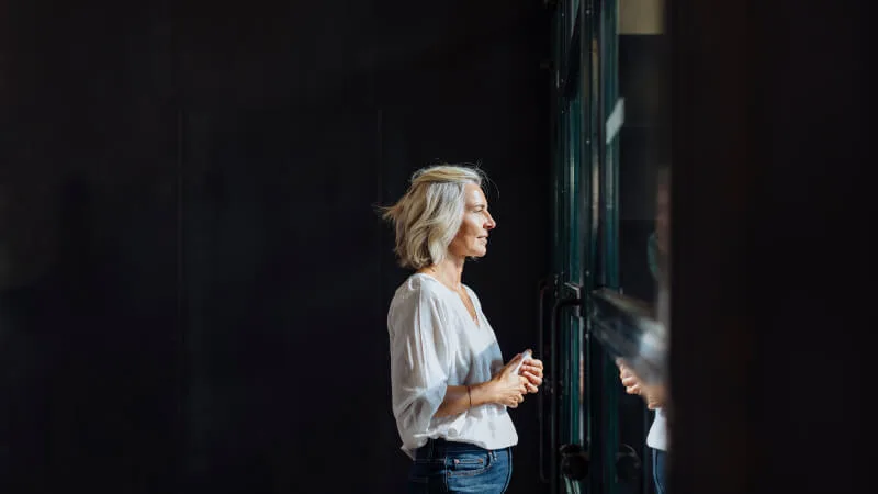 Woman gazing up optimistically out the window