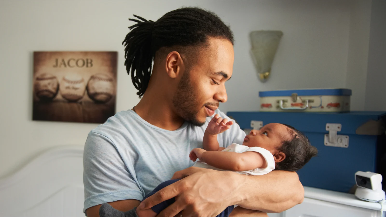 Disability insurance - Smiling father holding his baby in a nursery.