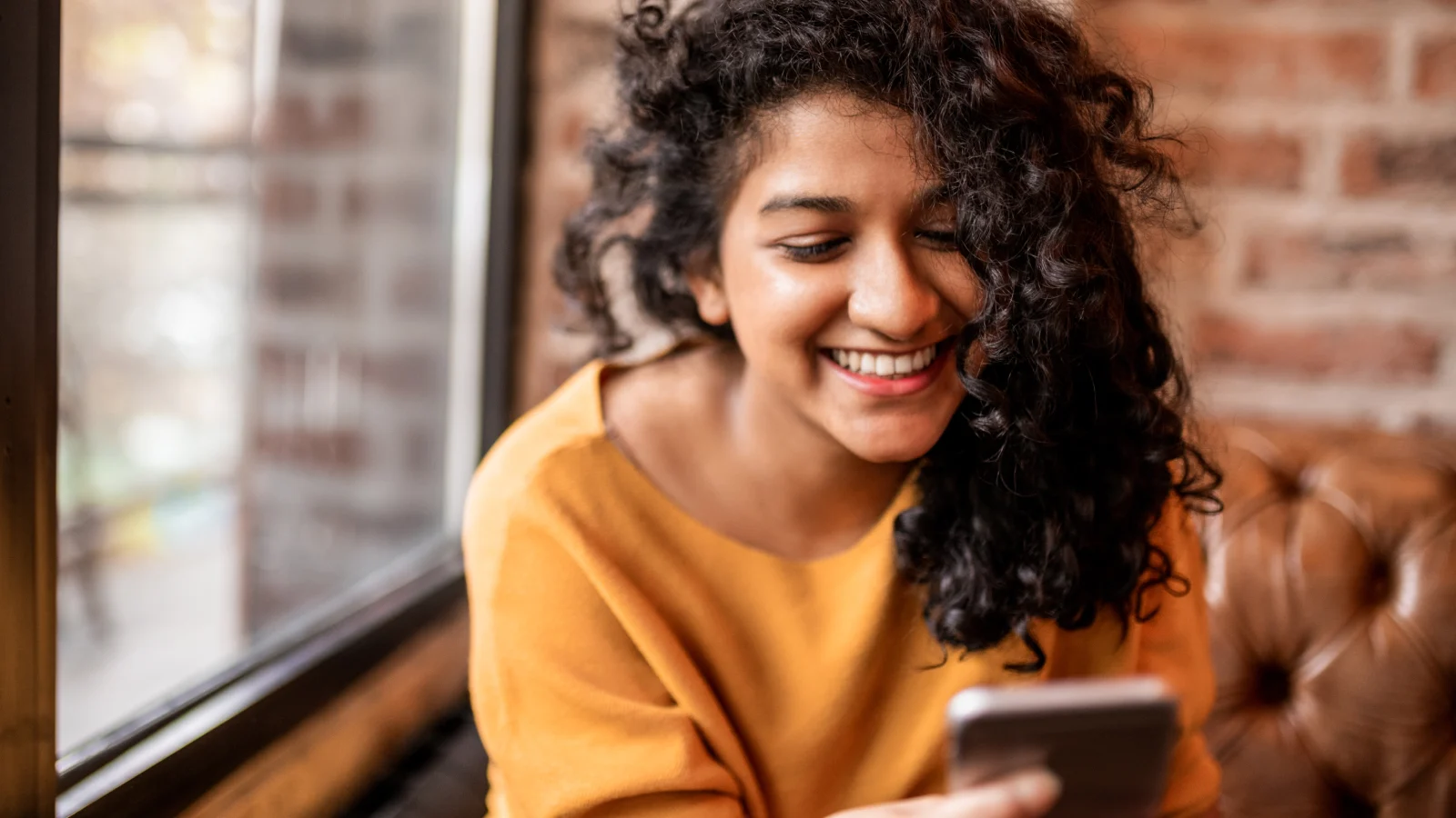 Secure access to care - curly haired teen girl looking at phone