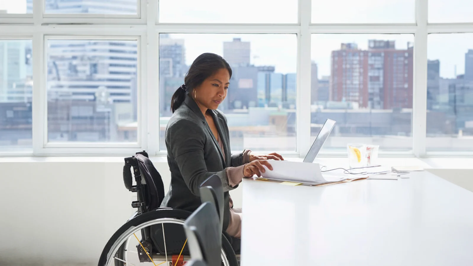 Disability insurance - Woman in a wheelchair working at her desk