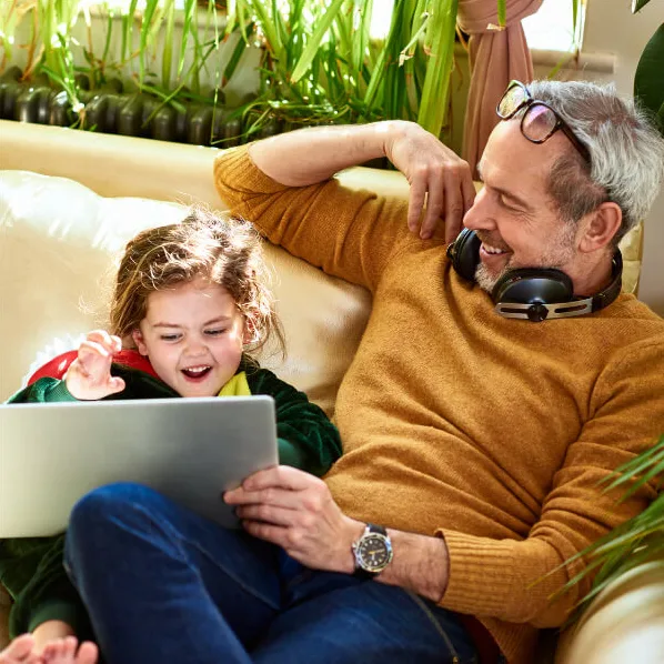 Dad and daughter holding a tablet.