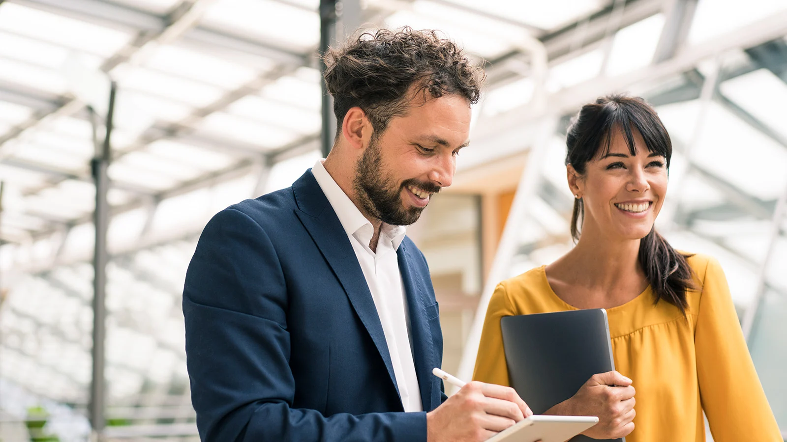 160 years of service - Man and woman walking through an office holding notebooks