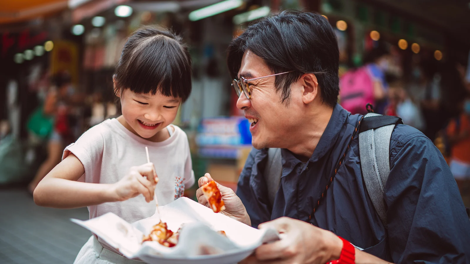 Father and daughter eating and smiling