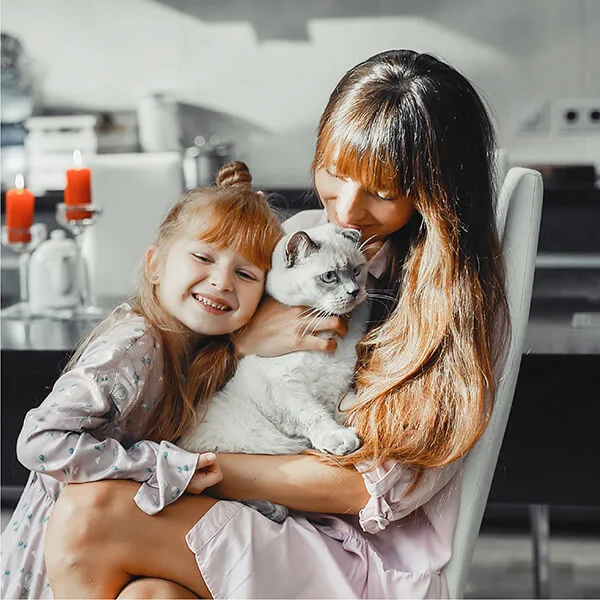 Mother and daughter hugging their cat.